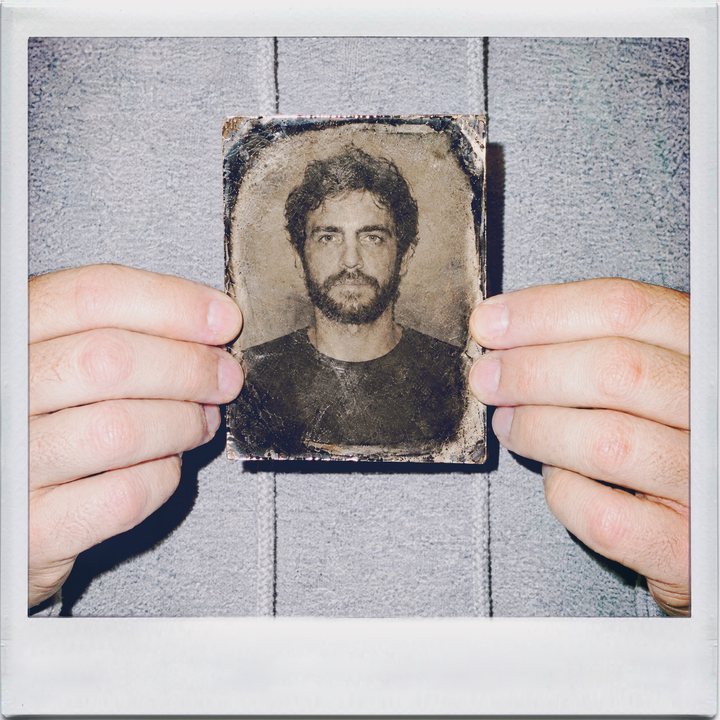 TinType, hands: a man holding a tintype plate of his own portrait