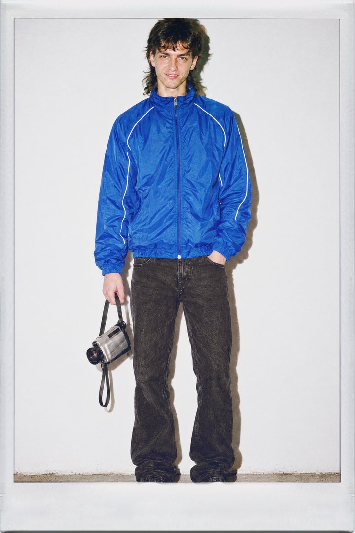Cinamatic, full length: a young man holding a camcorder and a tape