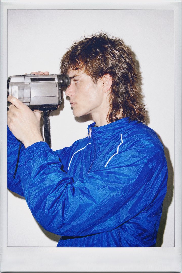 Cinamatic, profile: a young man holding a camcorder and a tape